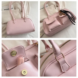 Detail view of pink leather underarm bag with silk scarf handle and dual front pockets