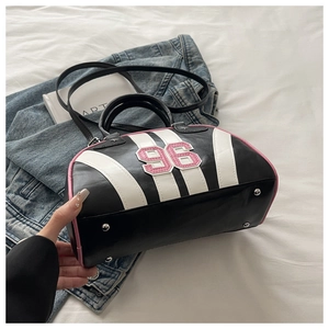 Detail of silver protective feet on striped leather bag with number 96 patch
