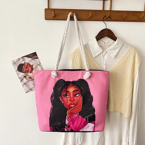 Detail of pink canvas tote featuring a cartoon portrait and white cotton rope handles