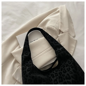 Detail of black leopard print hobo bag in velvet texture with stylish wide shoulder strap