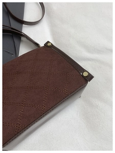 Detail of dark brown crossbody bag with quilted texture, smooth leather trim and gold studs