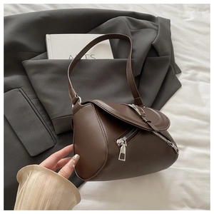 Detail view of deep brown leather crossbody bag with metal buckle and zipper closure