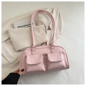 Detail of pink faux leather handbag with two front flap pockets and soft rectangular design