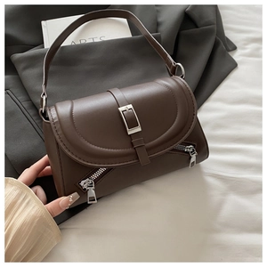 Detail of dark brown leather shoulder bag with silver buckles and decorative zippers