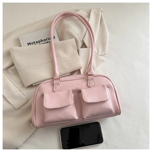 Detail of pink faux leather handbag showing front double pockets and smooth zipper closure