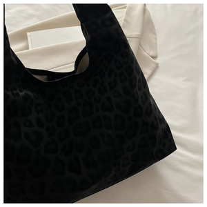 Close-up of leopard print tote bag in premium black faux suede with soft half-moon shape