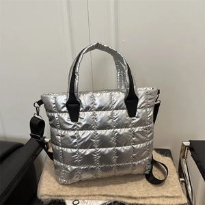 Silver quilted puffer tote bag with black handles and adjustable shoulder strap for women