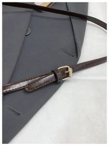 Detail of dark brown leather shoulder strap with adjustable golden metal buckle