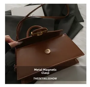 Detailaufnahme des sicheren Magnetverschlusses aus Metall an einer braunen Lederhandtasche