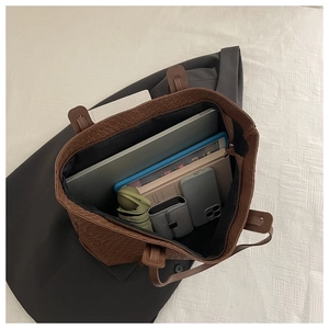 Interno spazioso di borsa tote marrone intrecciata con spazio per laptop e oggetti