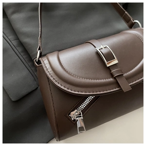 Detailed close-up of dark brown matte leather handbag with metallic zipper and buckle detail