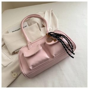 Pink leather shoulder bag detail with dual utility pockets and metal tennis racket charm