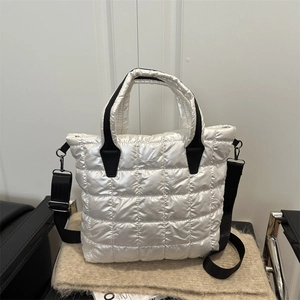 Quilted white puffer tote bag with black straps and adjustable nylon shoulder strap