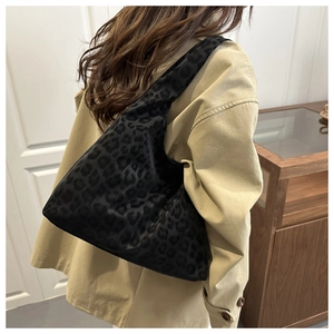 Detail of a chic leopard print hobo bag in black and grey, showing the soft fabric texture