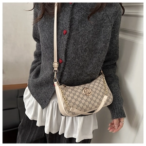 Dettaglio della borsa monogramma con logo M in metallo e pelle avorio su una modella