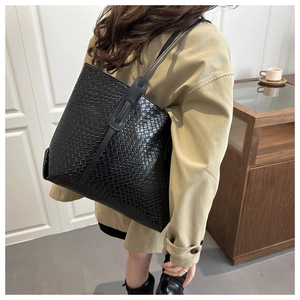 Dettaglio della borsa tote intrecciata nera con trama in pelle e tracolla di qualità