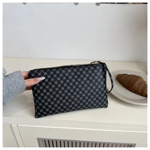 Detail of minimalist envelope clutch with geometric circular pattern and gold zipper