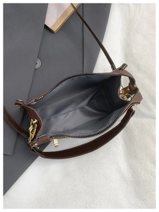 Top view showing the internal gray fabric lining and zipper of the brown leather handbag