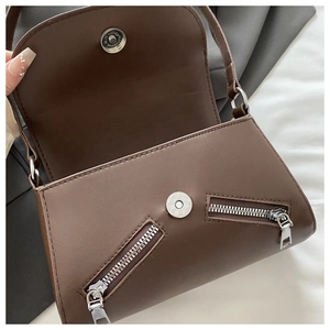 Detail shot of the interior of a dark brown faux leather crossbody bag with magnetic closure