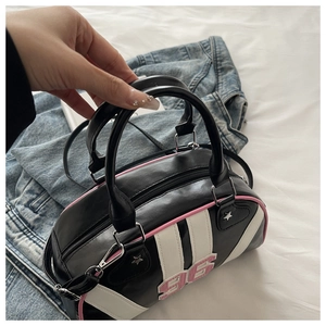 Close-up of black striped Boston bag with pink 96 patch and silver star accents