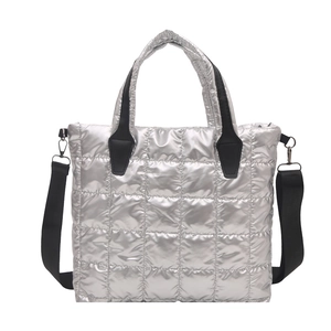 Sac fourre-tout argenté matelassé avec des lanières noires et une finition brillante chic