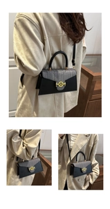 Detail of elegant two-tone crossbody bag with gold M buckle and adjustable strap