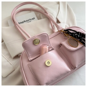 Pink faux leather shoulder bag with double magnetic pockets and a tennis racket charm