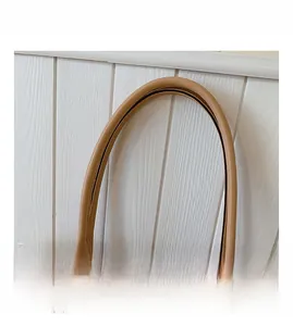 Detail of premium brown leather handles with metal rivets on a beige tote bag