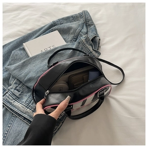 Detail view of the spacious interior capacity and pink trim of the contrast shoulder bag