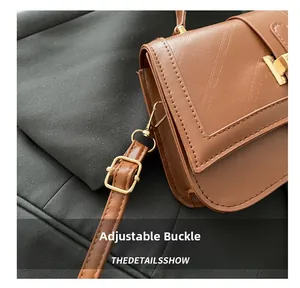 Close-up of golden adjustable buckle on brown quilted crossbody bag strap detail