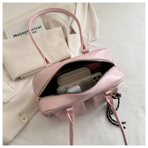Pink PU leather handbag detail showing spacious interior with wallet, phone and earphones
