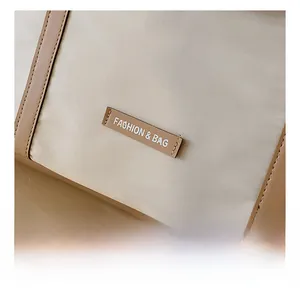 Detail showing the beige canvas fabric with leather trim and Fashion & Bag logo label