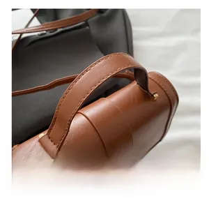 Detailed shot of brown leather handbag featuring fine stitching and gold metal hardware
