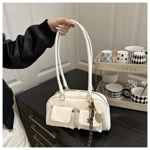 Detailed view of white vintage Boston bag featuring pebble leather and a tennis racket charm