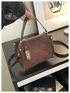 Detail of vintage brown quilted handbag with contrast leather trim and gold hardware