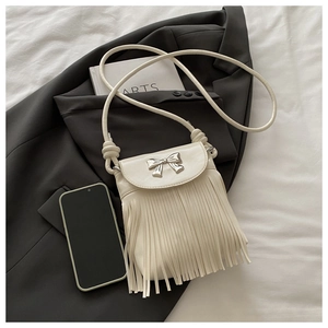 Détail d'un sac bandoulière en similicuir crème avec nœud argenté et longues franges