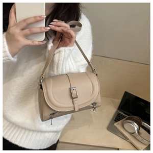 Detail of beige PU leather crossbody bag with silver buckle and decorative side zippers