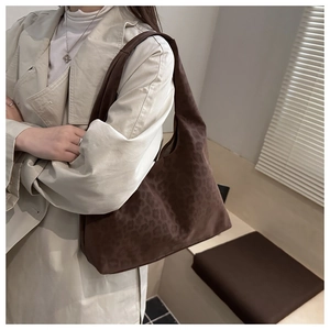 Close-up of stylish brown leopard print tote bag with soft suede texture on shoulder