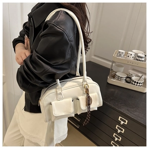 Detail of off-white faux leather handbag featuring dual front pockets and silk scarf accent