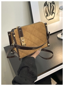 Close-up of vintage brown quilted suede handbag with contrast leather and gold twist lock