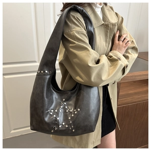 Detail view of large dark grey hobo bag featuring silver star-shaped metal rivets
