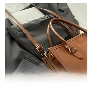 Détail d'un sac à main en cuir marron avec boucle en métal doré et bandoulière réglable