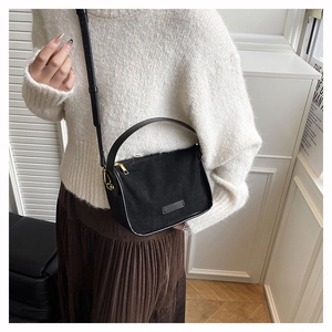 Detailed view of black PU leather crossbody bag with matte finish and gold metal zipper