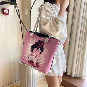 Detail of pink canvas tote featuring a cartoon girl print and white rope handles