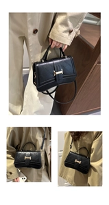 Detail of black quilted shoulder bag with gold H-buckle and adjustable strap
