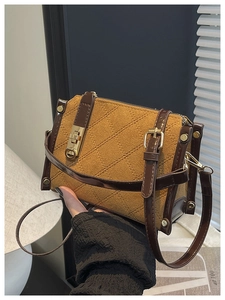 Detail of vintage quilted crossbody bag with brown suede texture and gold twist lock