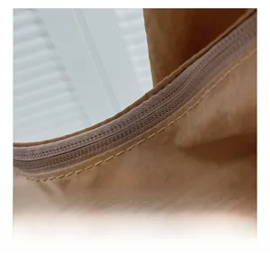 Macro detail of smooth zipper closure and neat stitching on a khaki tote bag