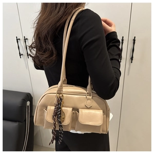 Detail of beige shoulder bag with two front pockets and decorative striped ribbon