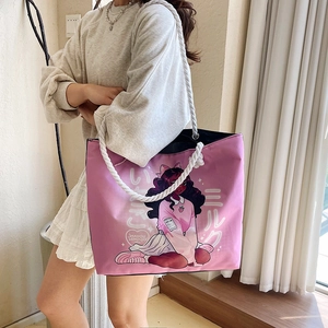 Detail of pink canvas tote bag featuring anime illustration and white rope shoulder straps