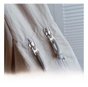 Macro shot of smooth dual zippers on a minimalist beige shoulder bag with nylon texture